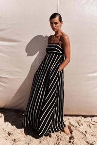 Chic backless striped maxi dress with thin straps and pockets against a beach backdrop