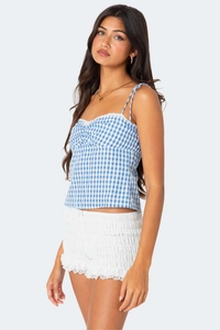 Detailed view of blue gingham camisole with ruched chest and delicate lace trim hem