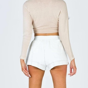 Vue détaillée du dos du haut en maille beige et du short blanc taille haute sur mannequin