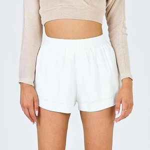 Détail du short blanc en coton à taille haute avec ceinture élastique et coupe ample