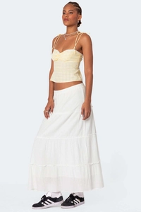 Detail view of yellow gingham camisole top paired with a tiered white maxi skirt