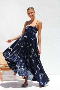 Detail of the navy blue satin summer dress featuring sun print and a flowy maxi hemline