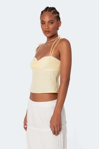 Detail view of yellow gingham cami top showing adjustable tie straps and ruched bust design