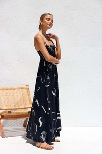 Detail of summer long dress featuring abstract white prints on black fabric with thin straps