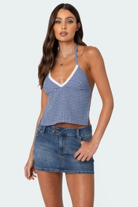 Detail eines blau-weißen Plaid-Halter-Tops mit Spitze und klassischem Denim-Rock