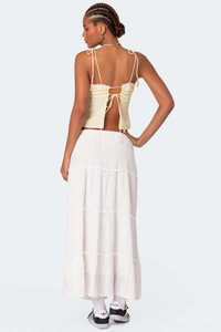 Detail of yellow gingham lace-up back top paired with a white tiered maxi skirt back view