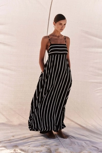 Detail of minimalist black and white striped maxi dress showing thin straps and fabric texture