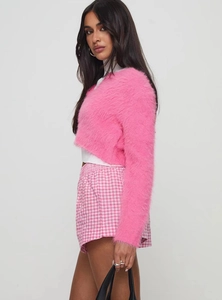 Detail of pink faux fur cardigan paired with stylish gingham high-waisted shorts