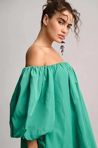 Close-up of green off-the-shoulder puff sleeve dress with silky texture and elegant silhouette