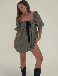 Detalle de minivestido de cuadros vichy en blanco y negro con mangas abullonadas y lazo