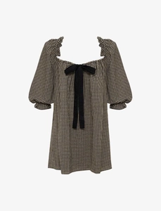 Detalle del escote cuadrado con volantes y lazo negro en vestido de cuadros con manga abullonada
