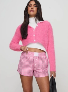 Detail of high-waisted pink gingham shorts paired with a soft pink knit cardigan