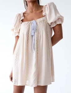 Détails de dentelle et col carré avec ruban sur une robe courte rose pâle