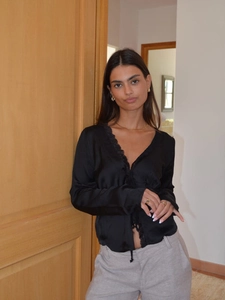 Elegant black satin V-neck shirt for women featuring delicate lace trim and long sleeves
