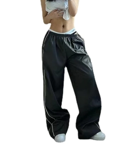 Detail of black sports trousers featuring adjustable drawstring waist and side white stripes