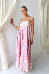 Detail of pink polka dot maxi dress featuring thin straps and striped hem pattern