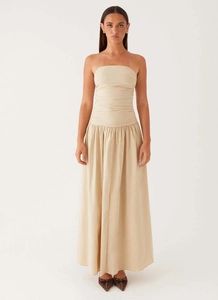 Dettaglio del corpetto arricciato e della gonna fluida su questo elegante abito lungo beige