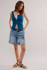 Close-up detail of blue ribbed knit tank top with button front and frayed denim shorts