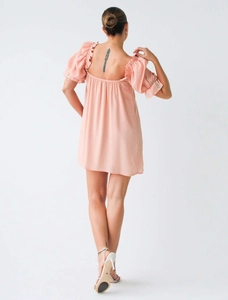Détail d'une mini robe rose avec manches bouffantes et dos nu élégant et chic