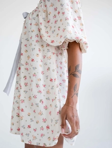 Detalle del vestido con mangas abullonadas, escote con cordones y estampado de flores