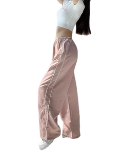 Detail view of pink wide-leg sweatpants featuring side white stripes and adjustable drawstrings