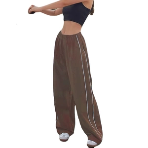 Detail of dark brown wide-leg trousers with side white stripes and elastic waist