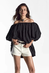 Detailed view of black off-the-shoulder puff sleeve dress in premium matte fabric