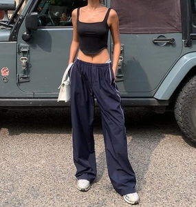 Detail of navy wide-leg sports pants with white side stripes and side drawstring design