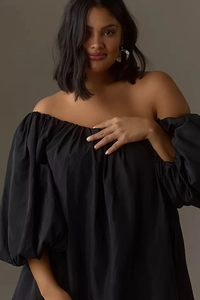 Detail of off-shoulder neckline and voluminous puff sleeves on a black satin dress