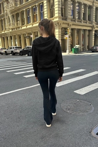 Close-up of slim-fit hooded sweatshirt and high-waisted flare pants for sports and leisure