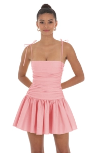 Détail de la robe rose à fines bretelles avec nœuds et tissu froncé effet amincissant
