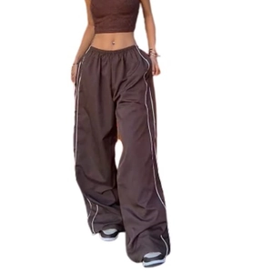 Detail view of brown wide-leg joggers with side white stripes and elastic waistband