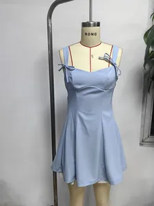 Détail d'une robe courte bleu clair avec bretelles à nœuds et coupe trapèze élégante