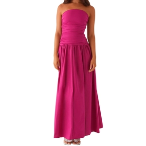 Dettaglio dell'elegante abito lungo a fascia magenta con gonna a pieghe e increspata