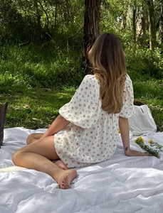 Detalle de vestido floral rosa con mangas abullonadas y espalda abierta al aire libre