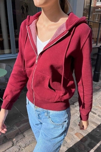 Outdoor shot of a wine red zip-up hoodie with drawstring hood and soft inner fleece lining