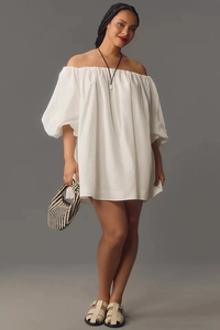 Detail of off-the-shoulder neckline and elegant puff sleeves on white summer dress