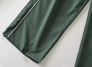 Detail of adjustable drawstring hem with white toggle on dark green casual pants