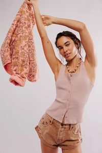 Detail view of mauve ribbed knit top with buttons paired with denim shorts and floral jacket