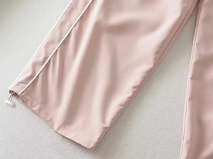 Detail view of pink casual pants with white side stripes and adjustable drawstring cuffs