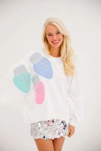 Detail of Christmas white sweatshirt featuring bulb patches with silver sequin stars