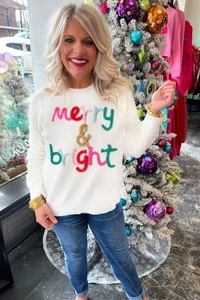 Detail of colorful merry and bright plush embroidery on a white Christmas sweater