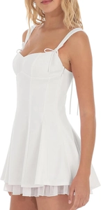 Détail de la robe courte blanche avec bretelles à nœuds et ourlet à volants superposés
