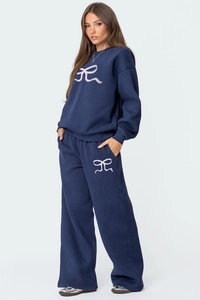 Détail de l'ensemble sweat bleu marine avec motif de nœud rose et pantalon large fluide