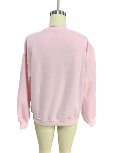 Detail view of the back of a light pink crewneck sweatshirt with ribbed cuffs and hem