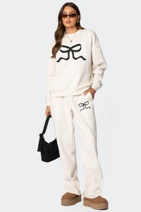 Détail de l'ensemble sweat et jogging crème avec motif de nœud noir et tissu polaire doux