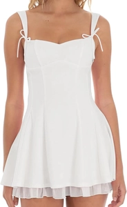 Détail de mini-robe blanche avec bretelles à nœuds et ourlet plissé élégant