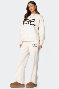 Détail d'un ensemble de détente crème avec des motifs de nœuds noirs sur le sweat-shirt