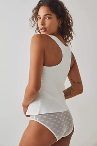 Detailed view of white ribbed knit vest featuring delicate lace edges and sheer dot pattern