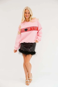 Detail of pink Christmas sweatshirt with reindeer antler embroidery and sequin feather skirt